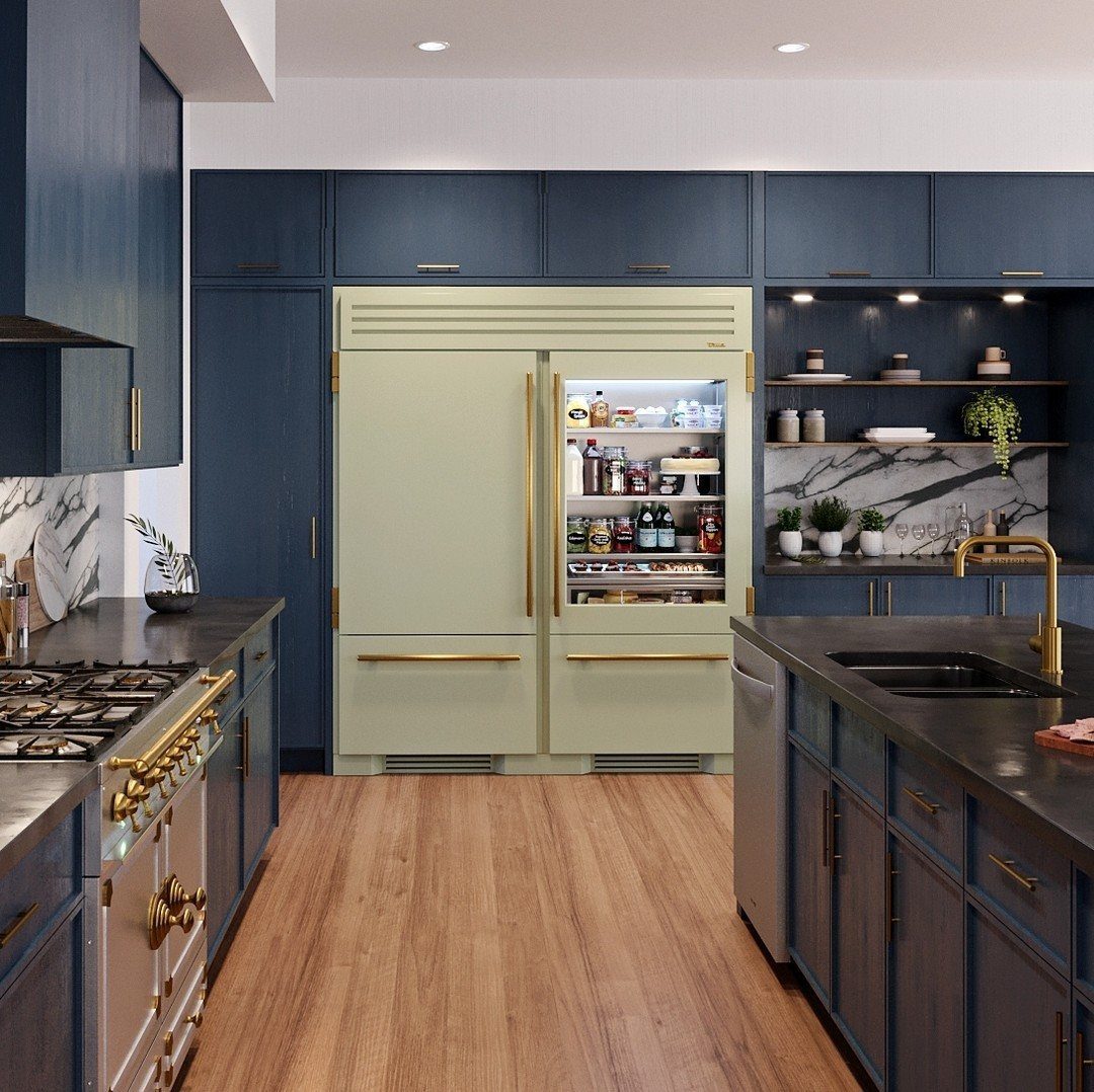 Large pale green built-in refrigerator with gold handles stocked with food in a modern kitchen.