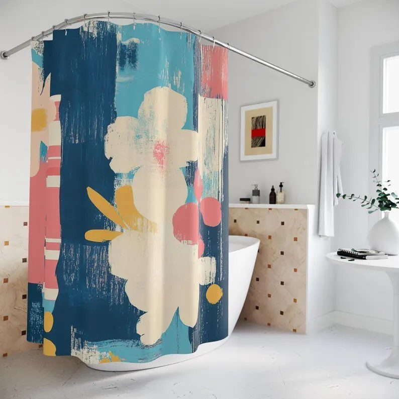 Abstract floral shower curtain in blue, pink, and cream hanging over a white bathtub.