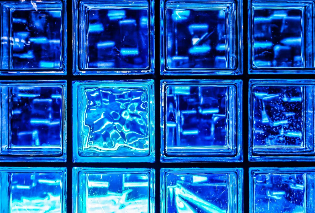 Translucent blue glass blocks with textured surfaces arranged in a glowing grid pattern.