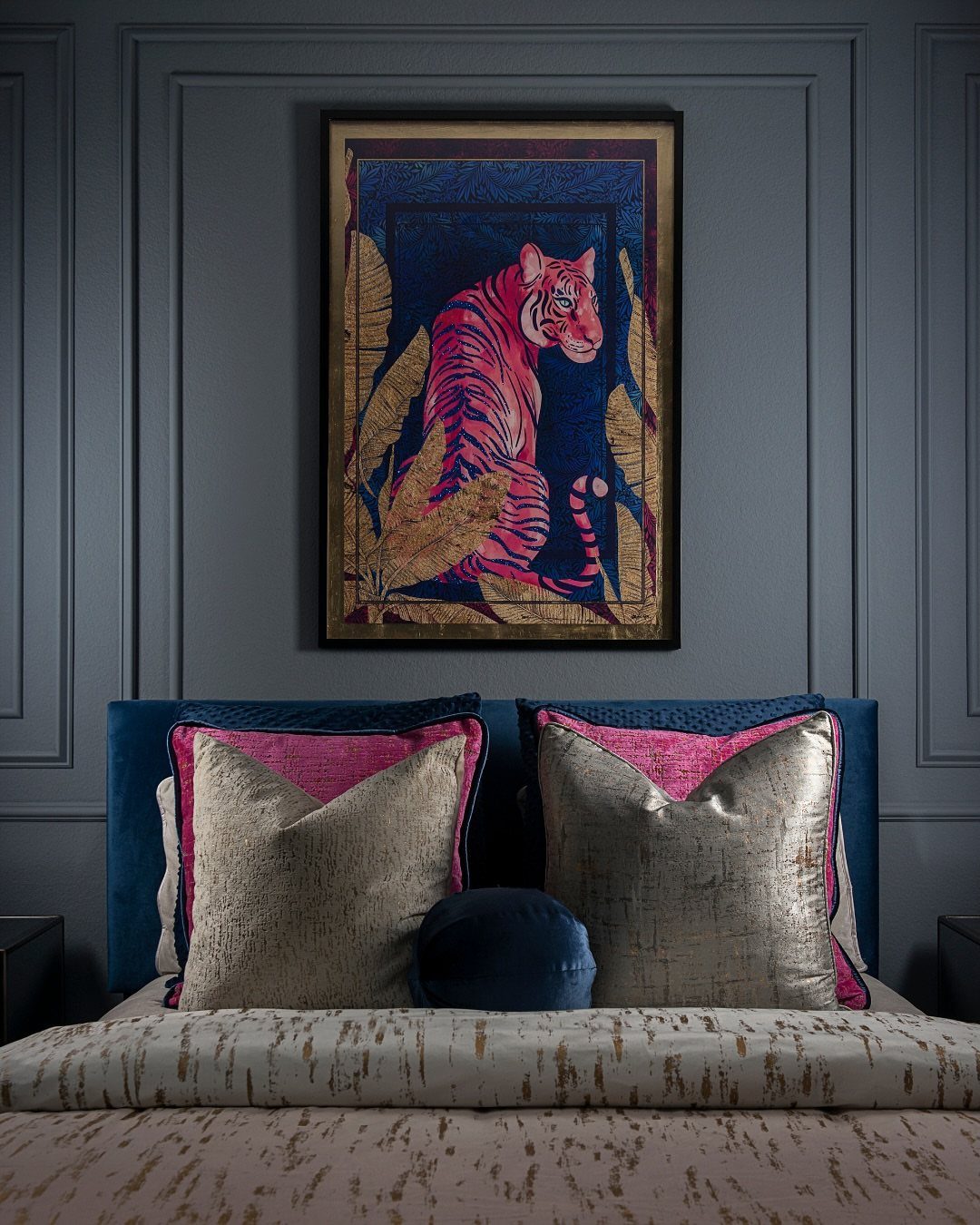 Large framed tiger artwork hanging on a dark grey paneled wall above a bed.
