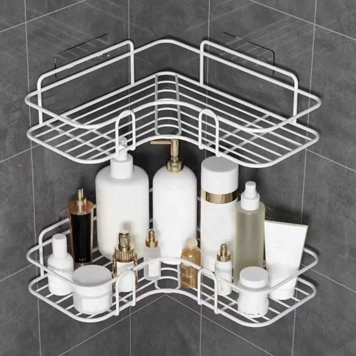 White wire metal corner shelves holding various white cosmetic and skincare bottles against grey tiles.