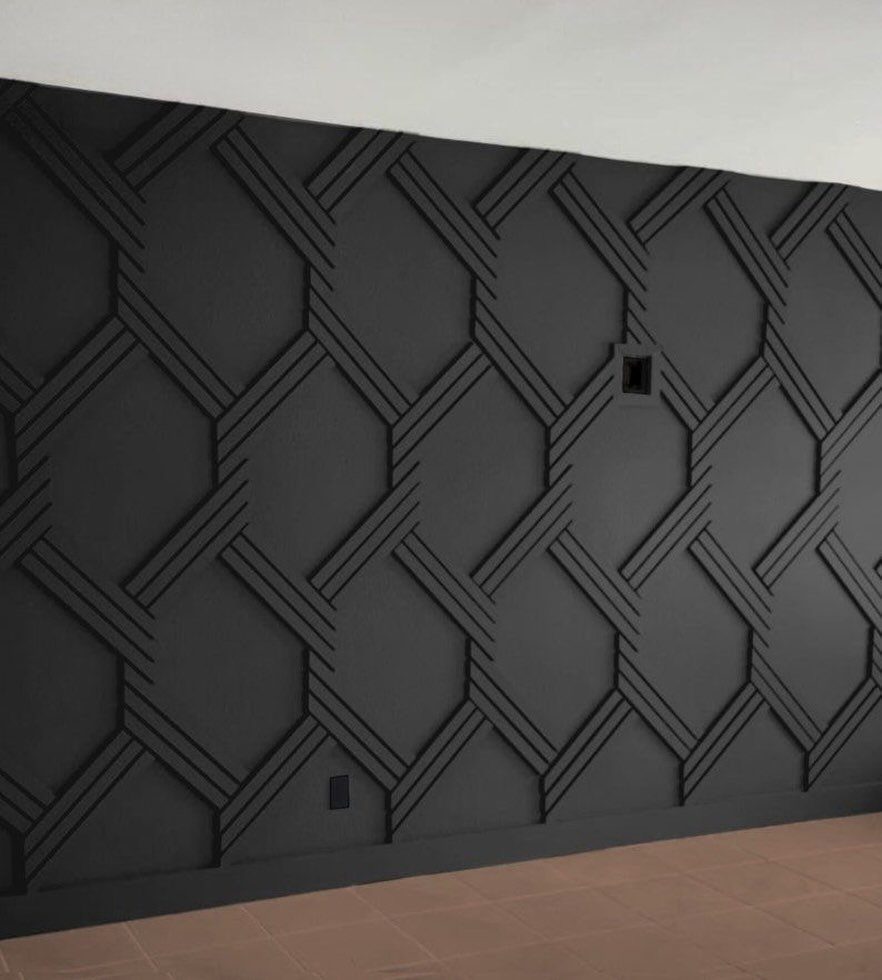 Black geometric patterned accent wall with raised three-dimensional interlocking lines and hexagonal shapes.