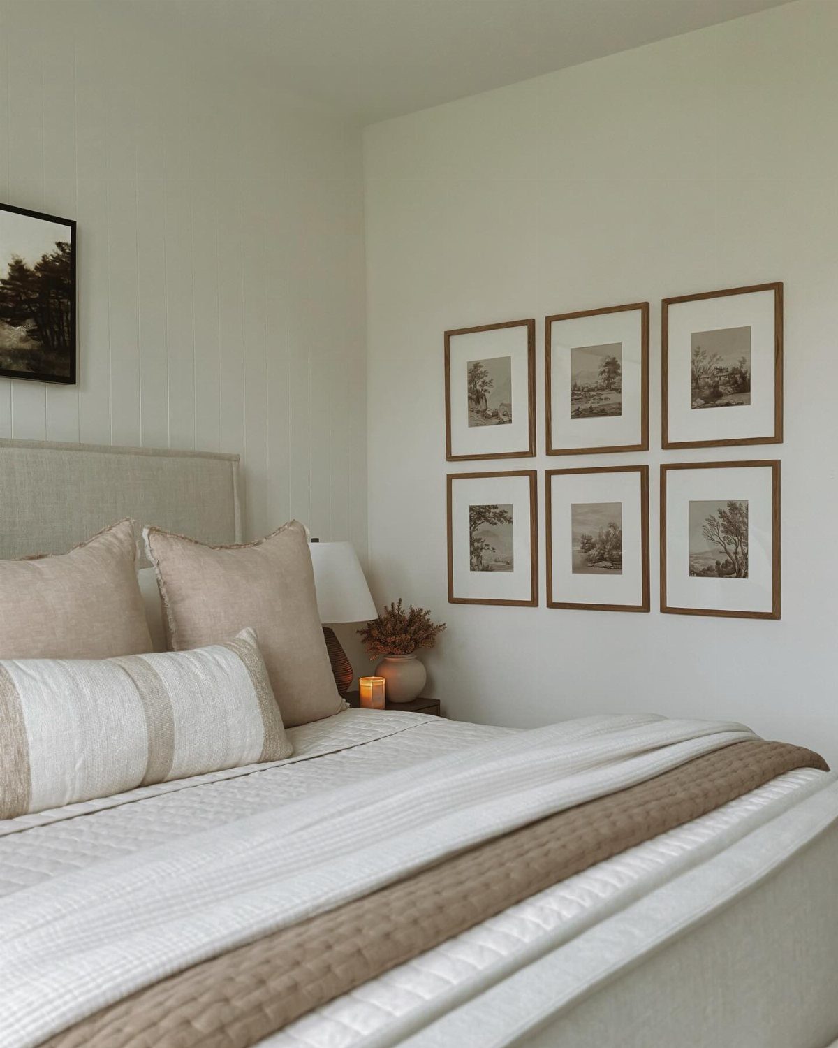 Six framed landscape art prints arranged symmetrically on a white bedroom wall.