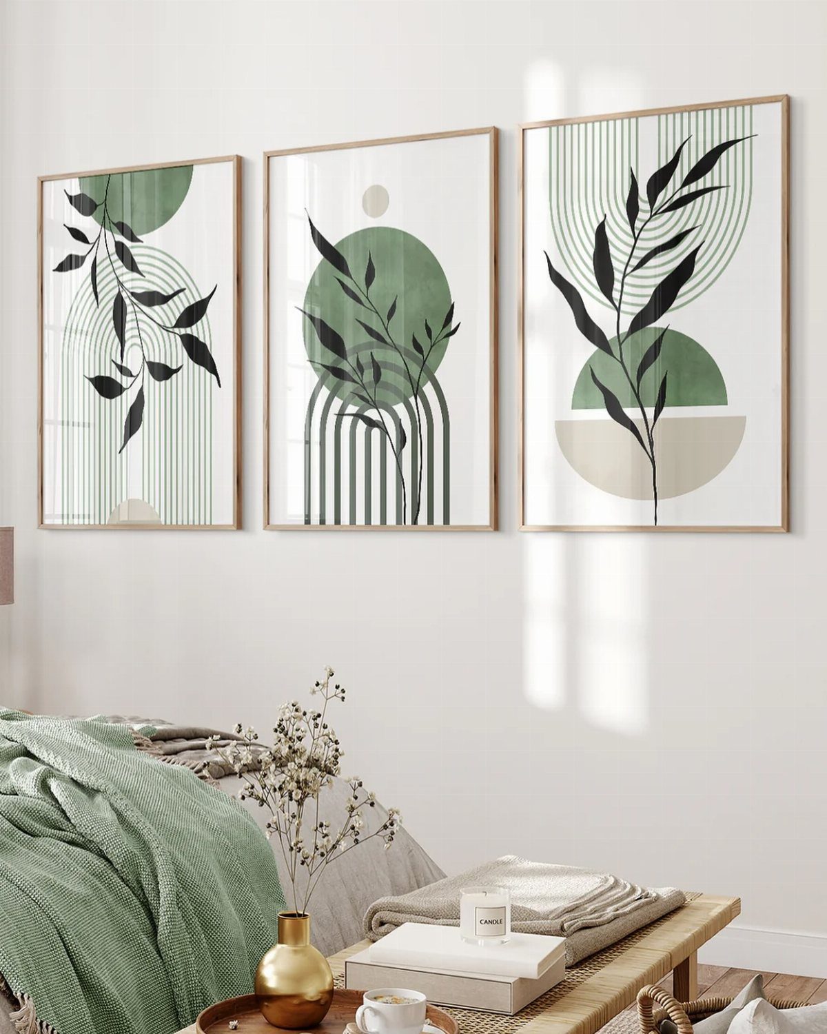 Three botanical art prints in light wood frames hanging on a white bedroom wall.