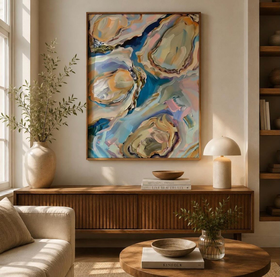 Abstract coastal art in blue and gold hangs above a wooden sideboard in a beige living room.