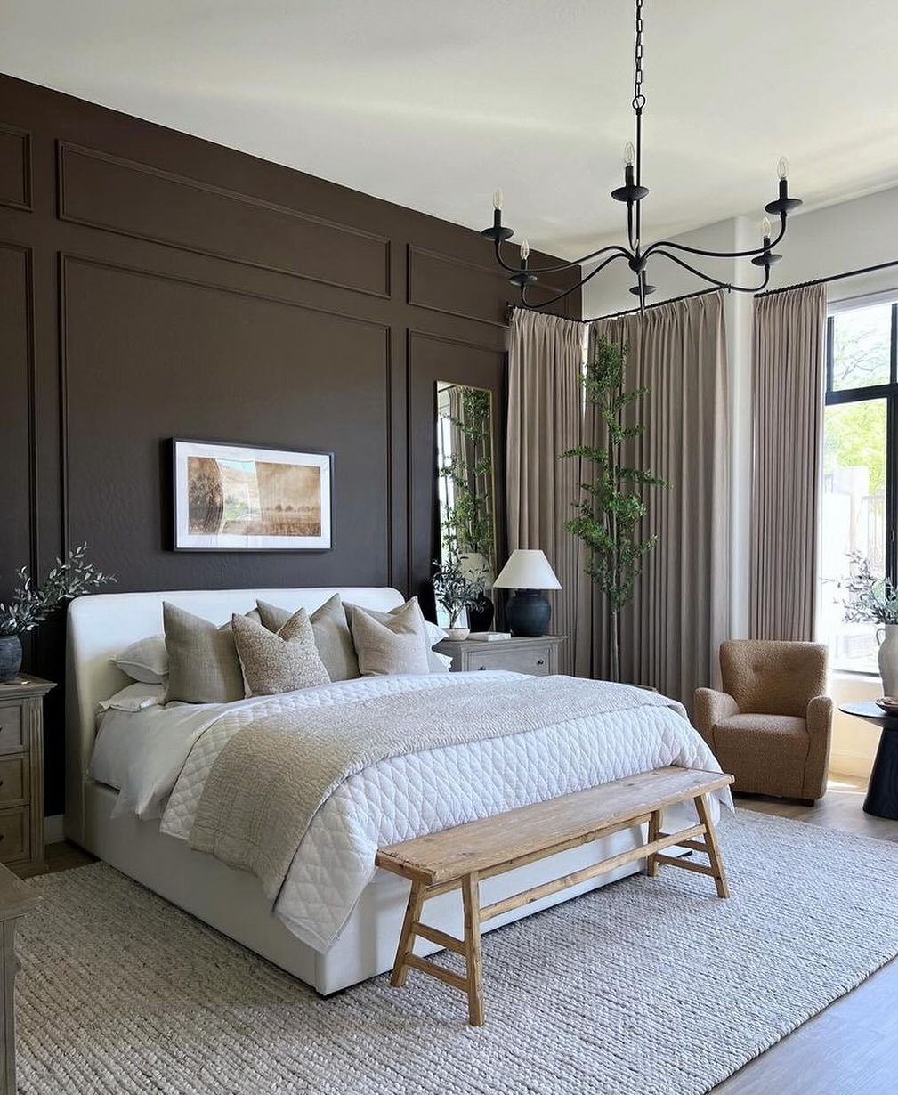 A bedroom with a rich chocolate brown paneled accent wall and white upholstered bed.