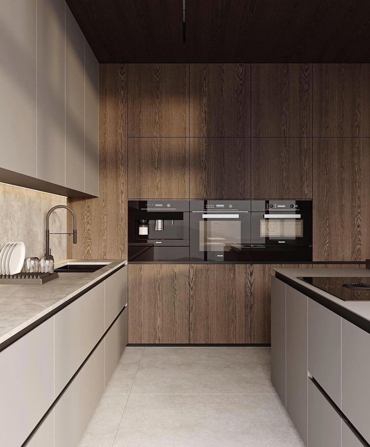 Modern kitchen with light grey cabinets, dark wood pantry walls, and integrated black appliances.
