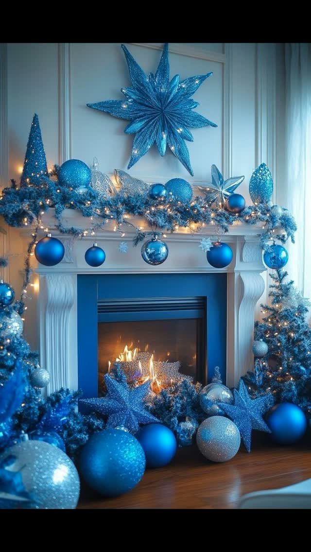 Blue ornaments and garlands decorating a white fireplace mantel with a glowing fire.