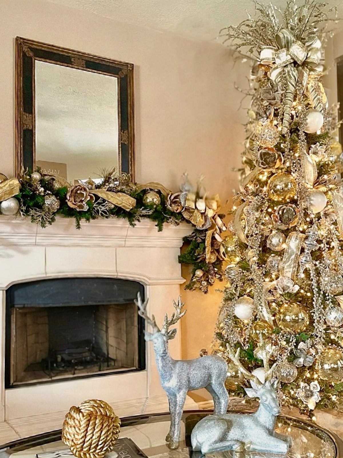 A gold and silver decorated Christmas tree standing next to a white fireplace mantel.