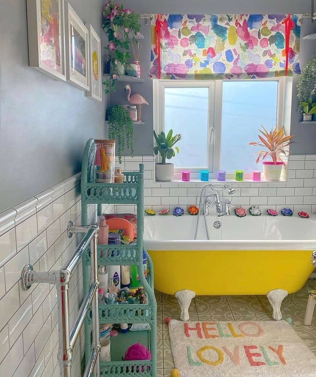 Yellow clawfoot bathtub and colorful decor in a bright, eclectic bohemian style bathroom.