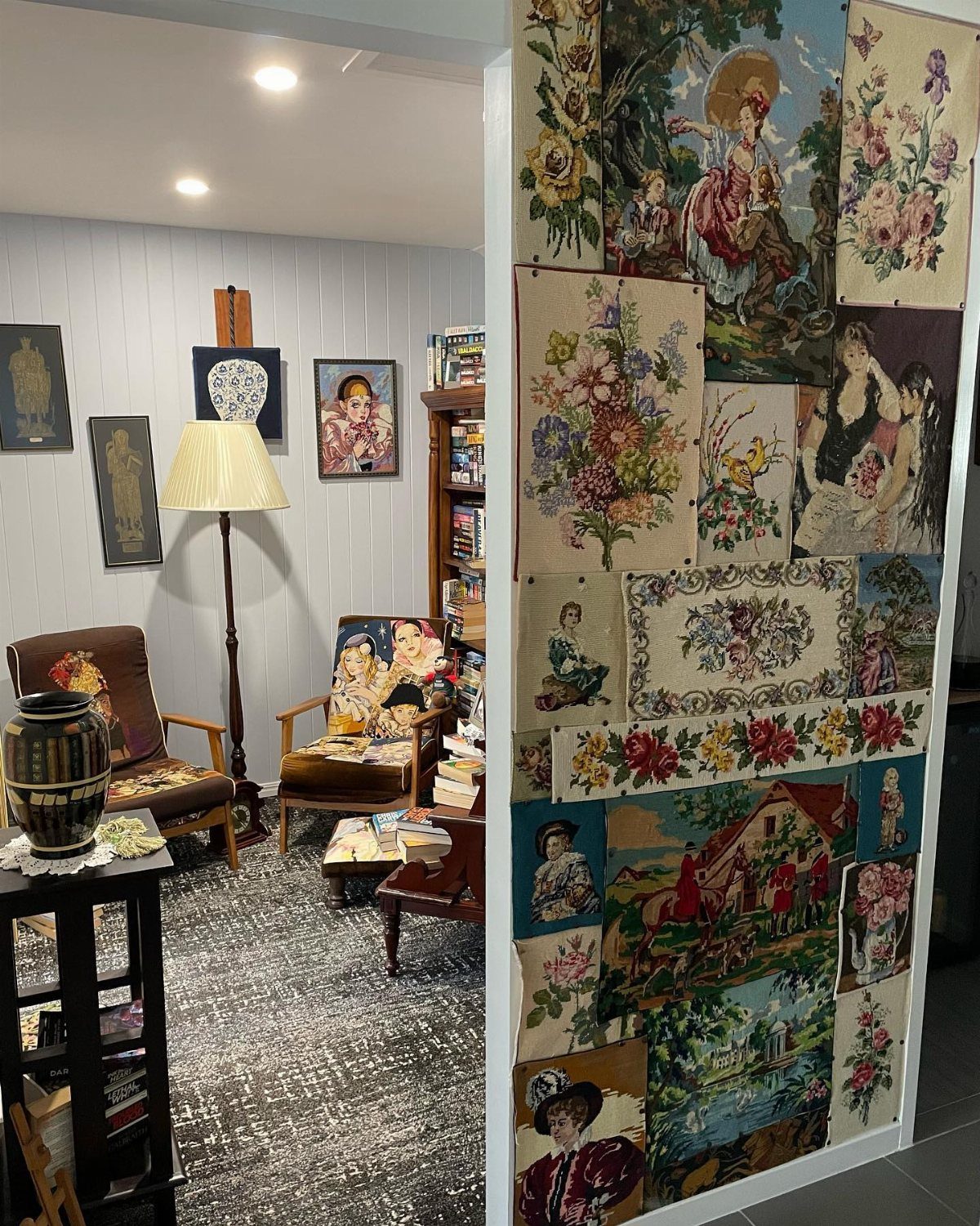 Patterned textile tapestries pinned to a white wall in a room with armchairs.