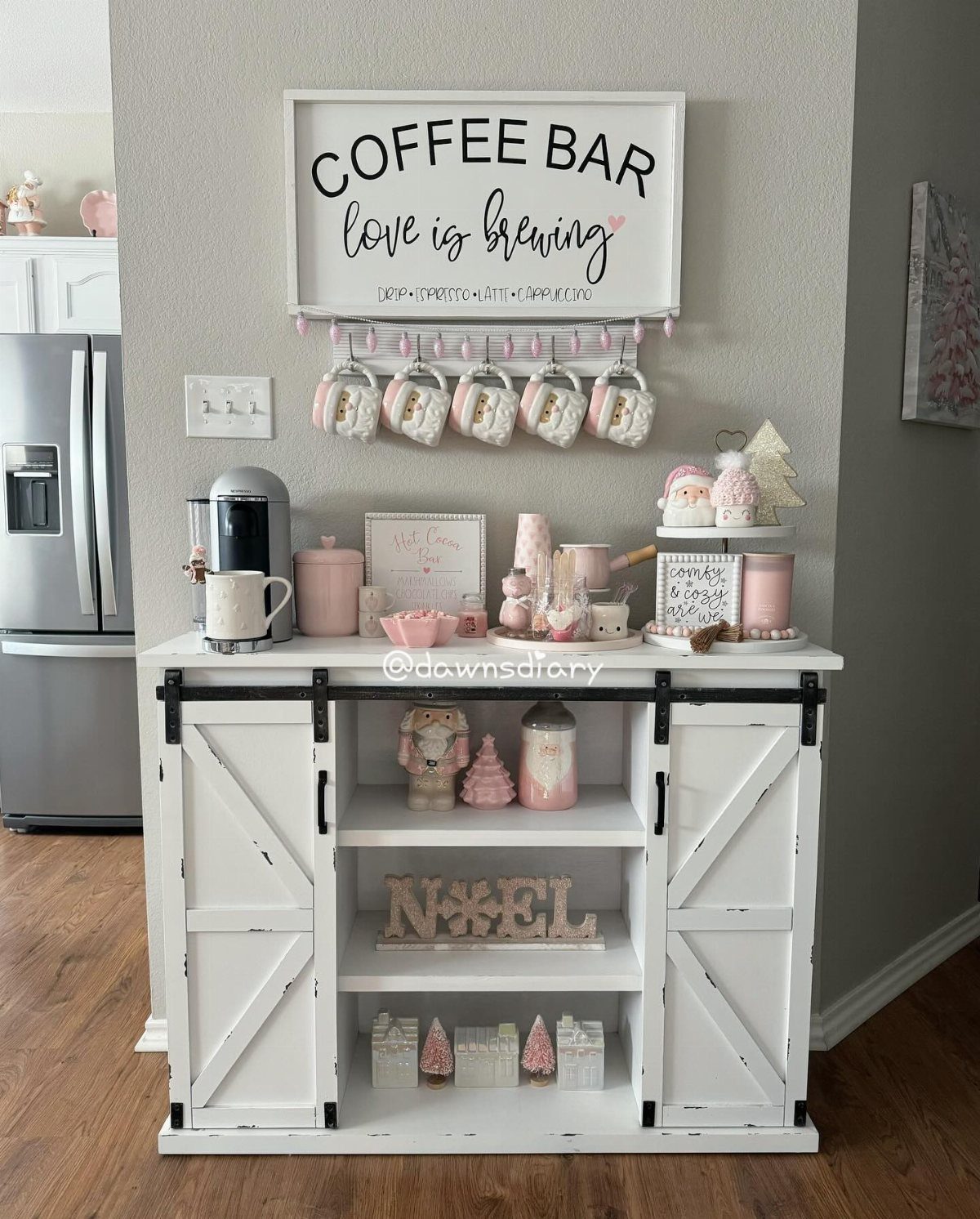 A white coffee bar cabinet decorated with pink accents and holiday themed decor.