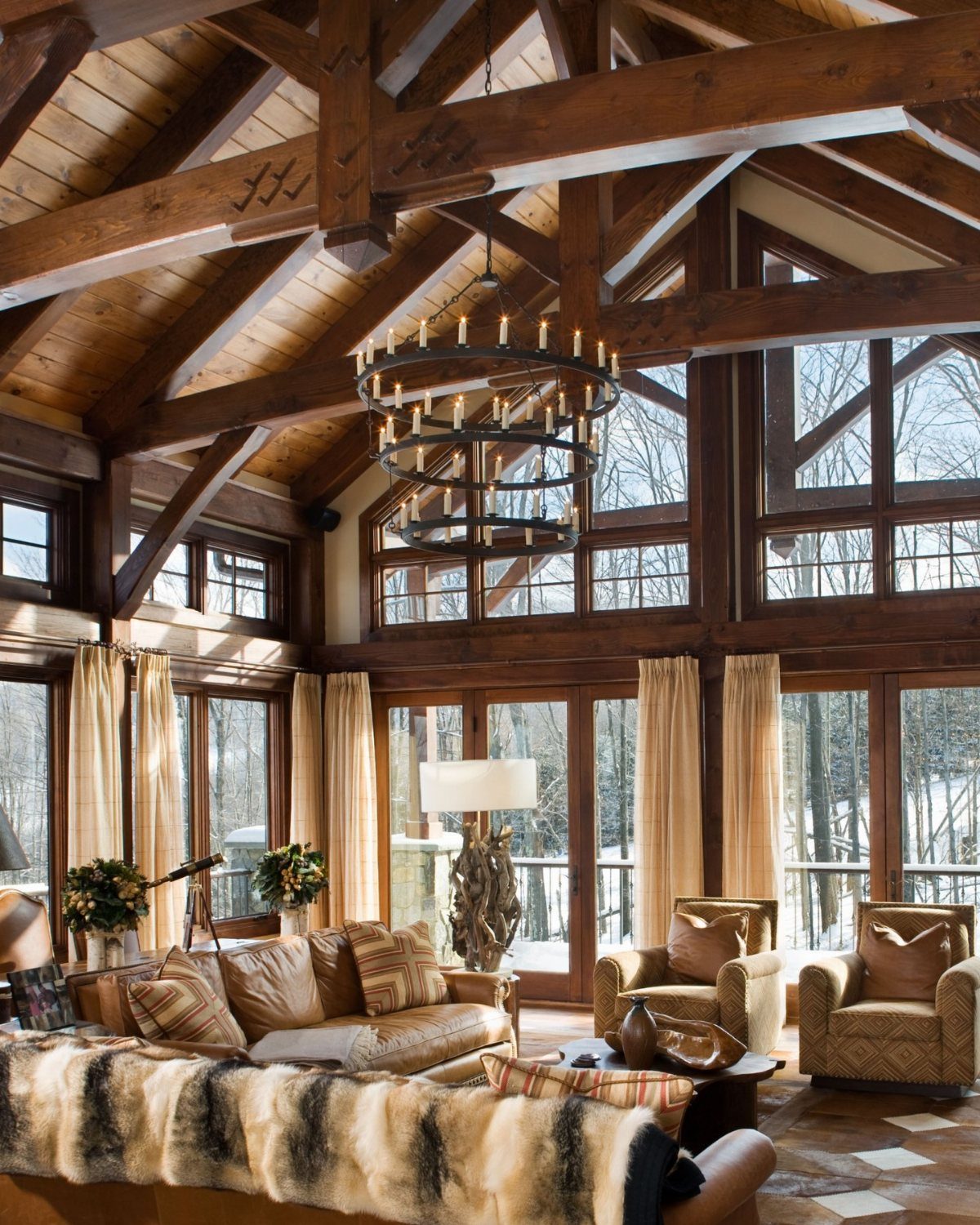 Large dark wooden beams supporting a vaulted ceiling in a rustic living room.