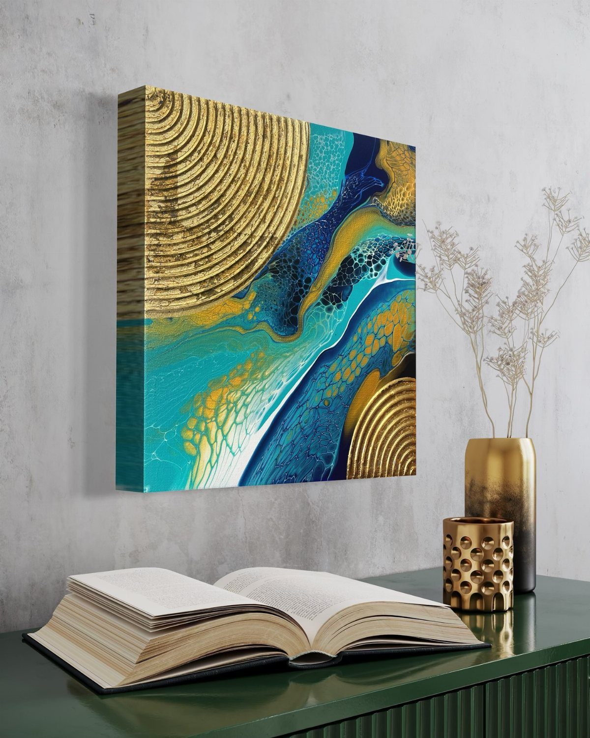 Abstract teal and gold patterned canvas art hanging on a grey wall above an open book.