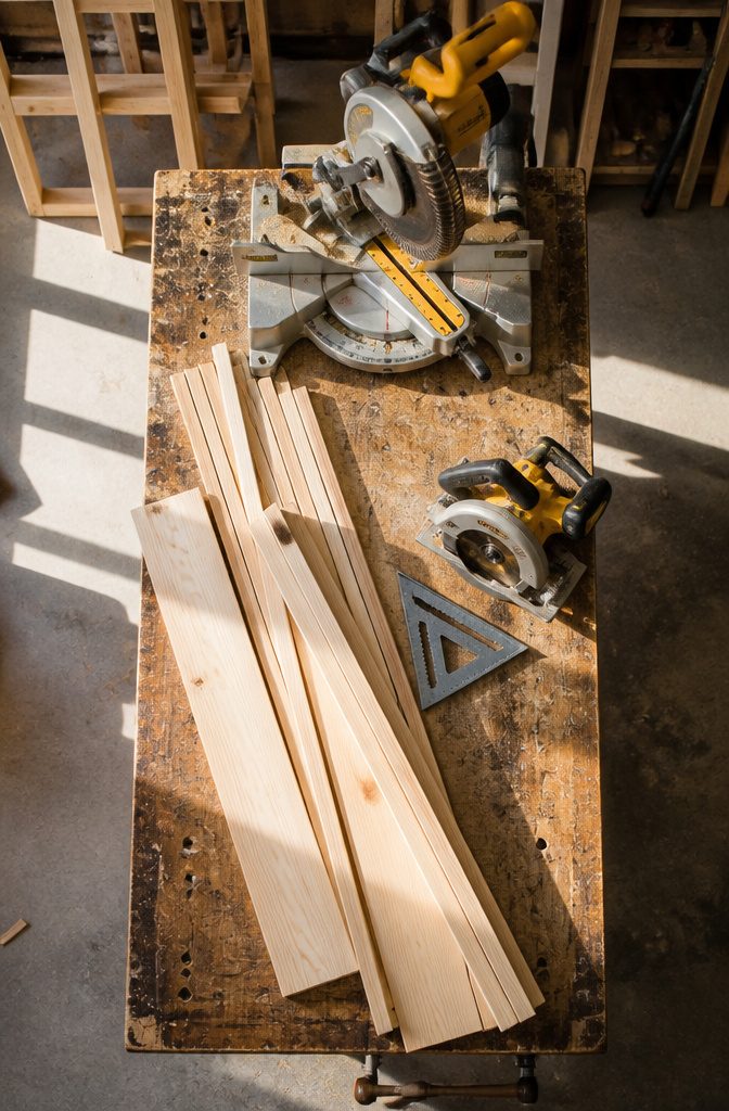 Lumber and tools laid out for constructing a corner bookshelf.
