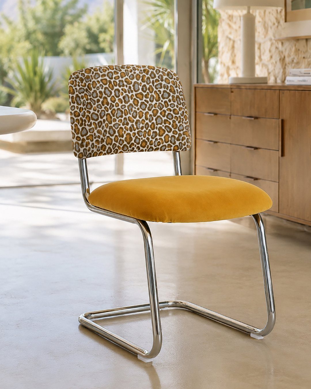 Leopard print accent chair with a yellow velvet seat and chrome metal frame.