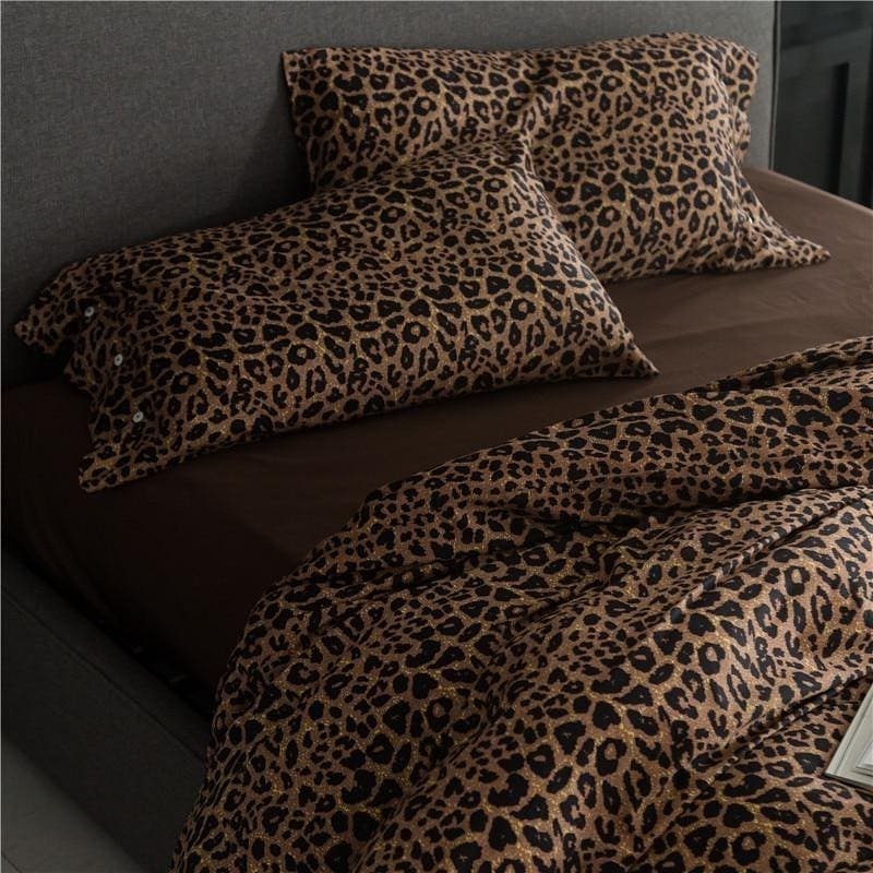 Leopard-print pillowcases and a matching duvet cover on a bed with a grey headboard.
