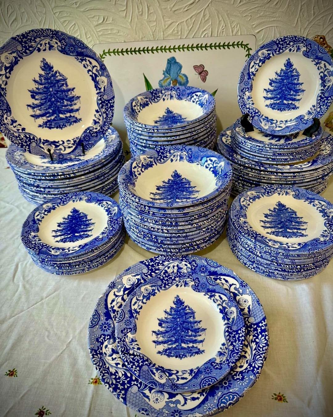Stacks of blue and white patterned plates and bowls with Christmas tree designs.