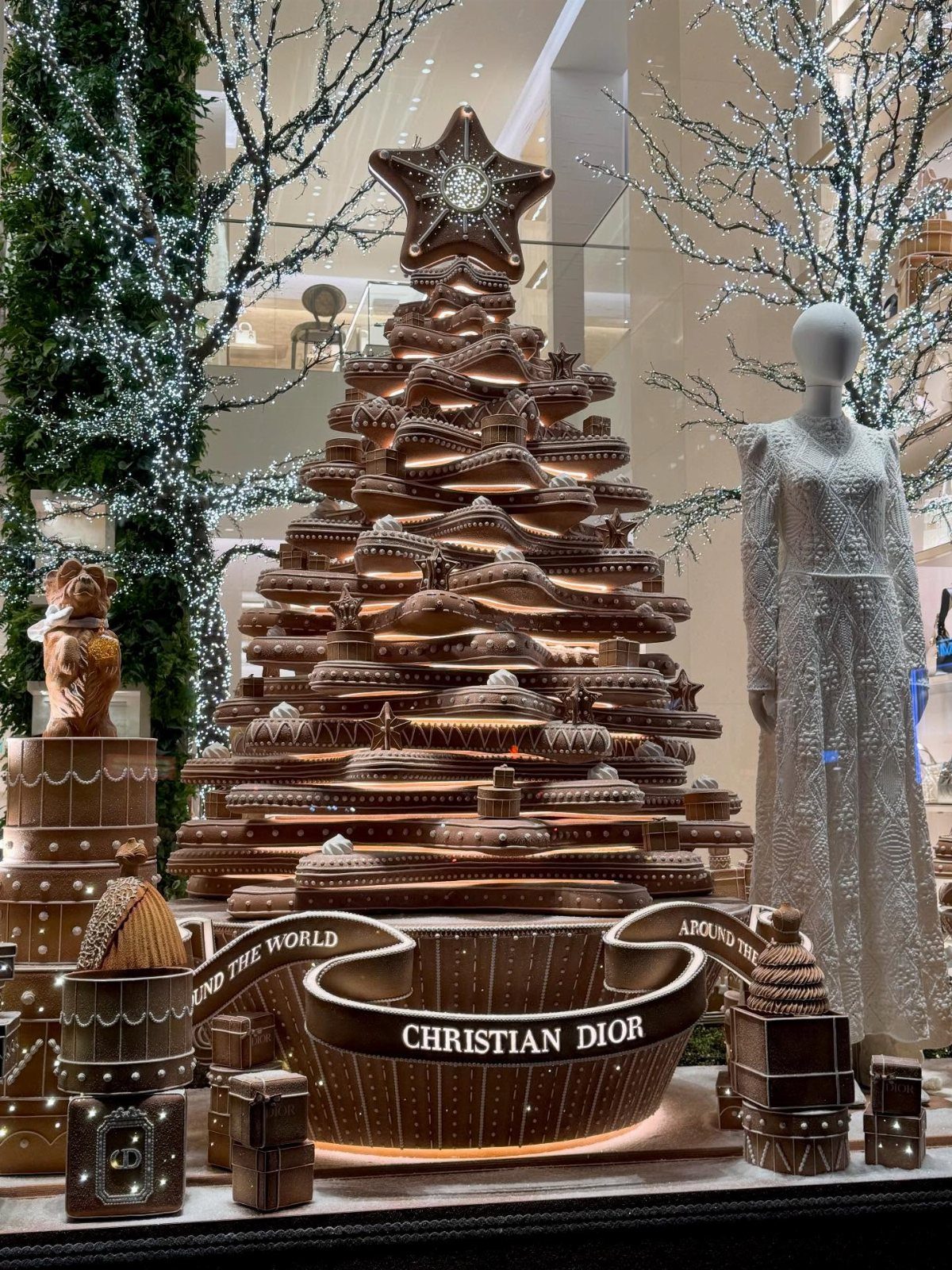 A massive tiered gingerbread Christmas tree decoration with white icing details on a display stand.