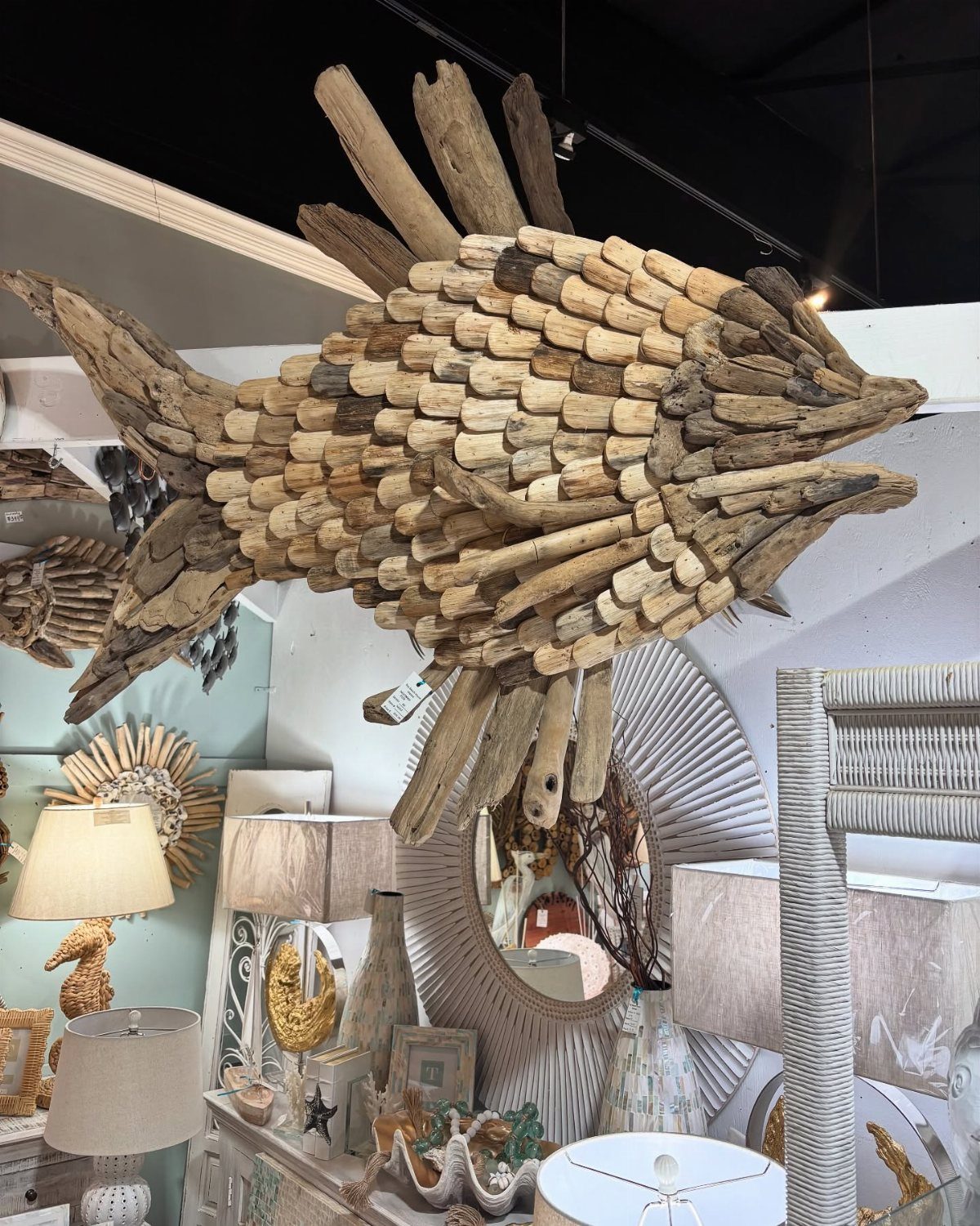 Large decorative fish sculpture constructed from various pieces of natural driftwood.