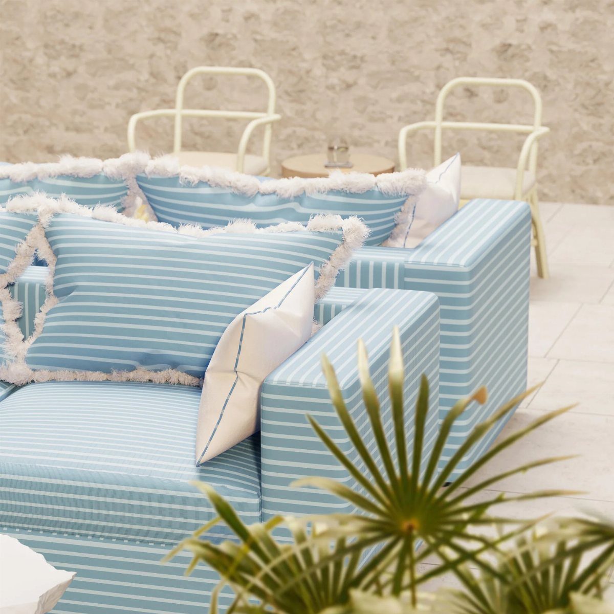 Blue and white striped sofa with fringed pillows in a bright outdoor setting.