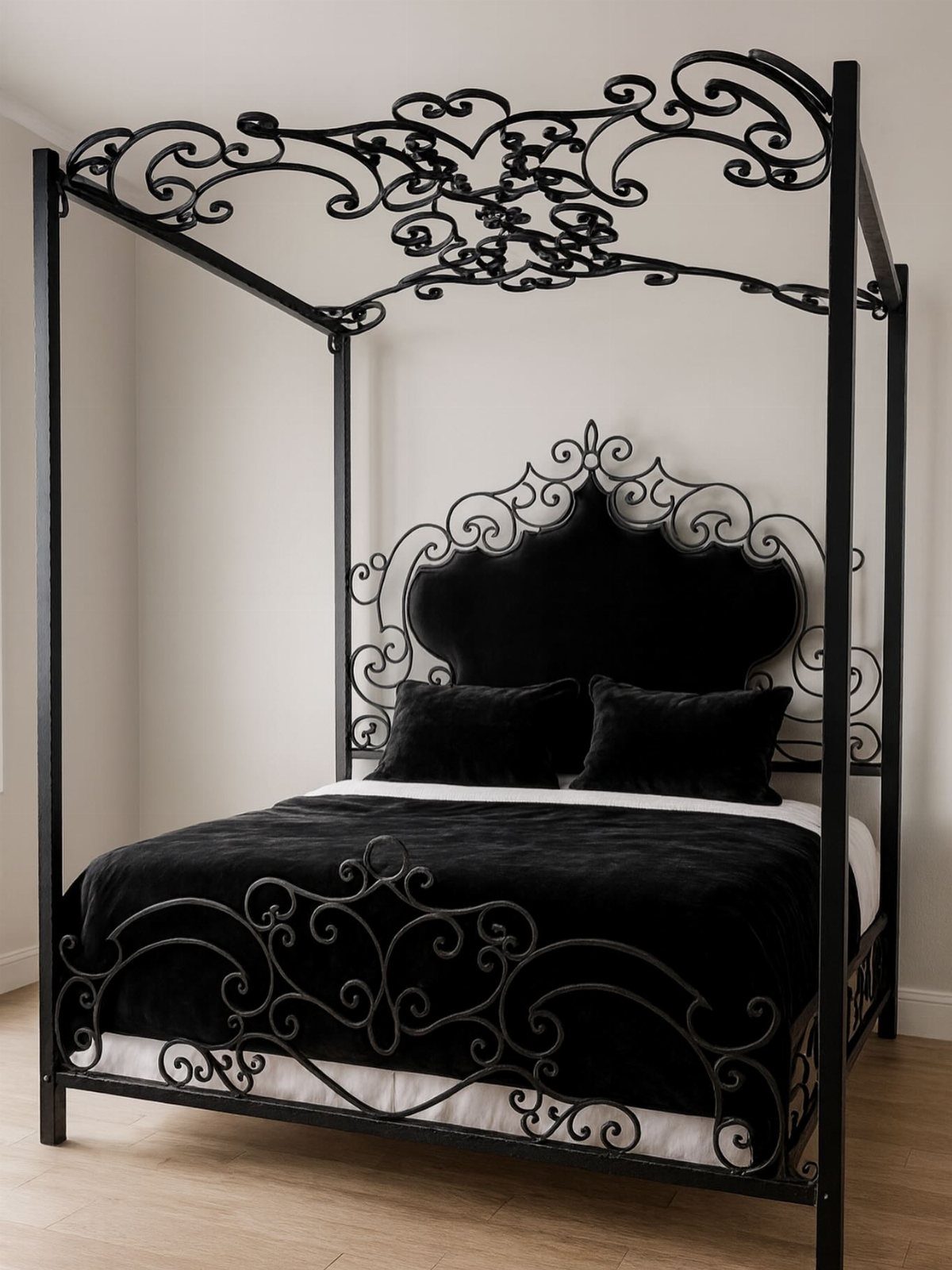 Black wrought iron canopy bed with velvet bedding in a bright room.