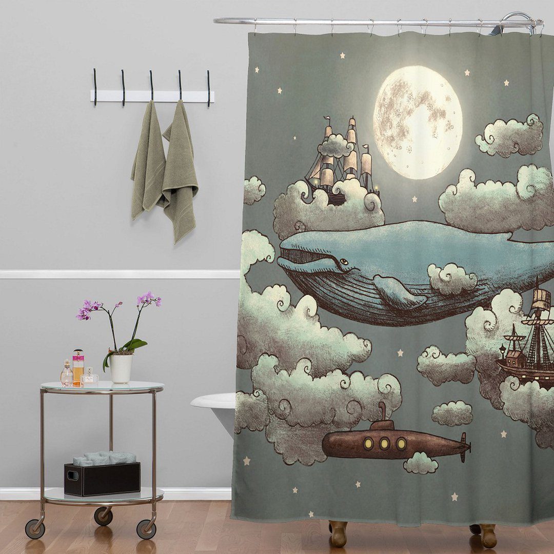 Whimsical shower curtain with a flying whale, clouds, moon, and a submarine in a bathroom.