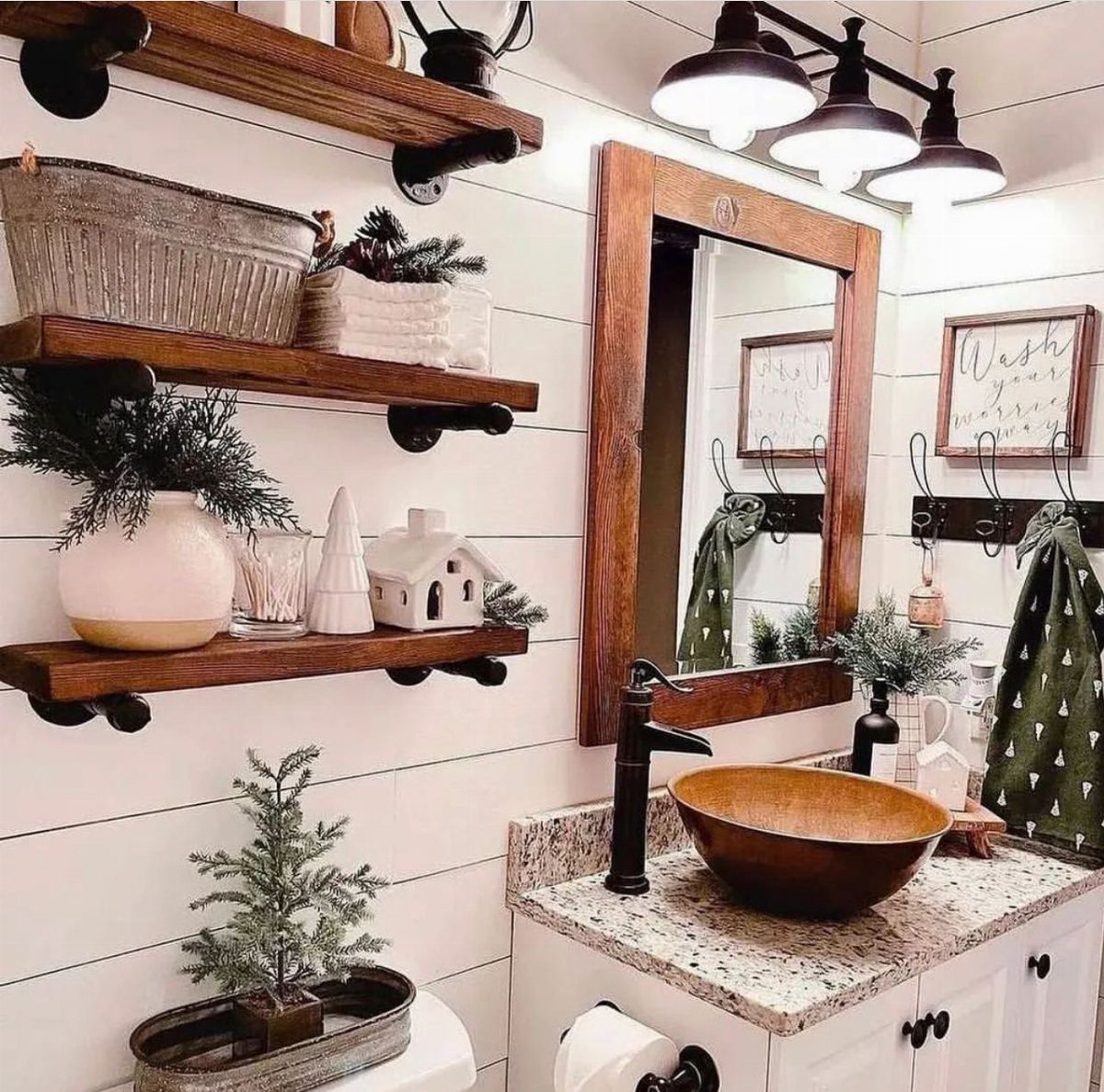Small evergreen plants in white and wooden containers decorating rustic bathroom shelves and countertops.