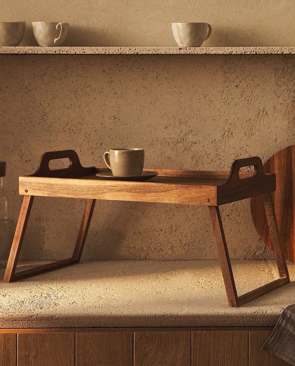 A wooden serving tray with a ceramic mug on a stone countertop.