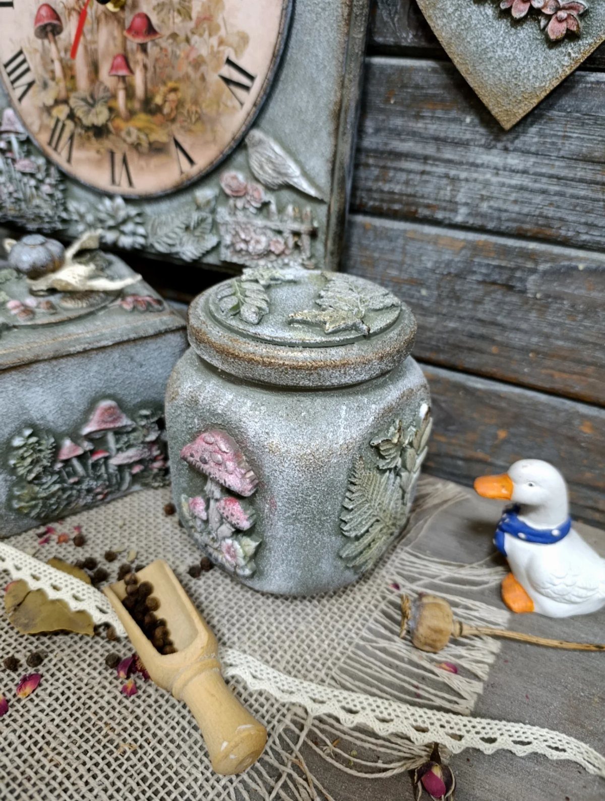 Whimsical cottagecore decor featuring mushroom-themed ceramics, a small duck figurine, and a wooden scoop.