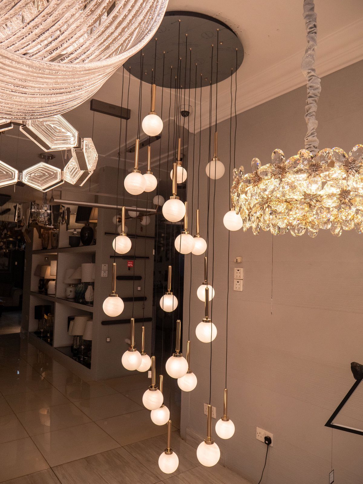 Modern pendant lights with white globe bulbs hanging from a black ceiling fixture.
