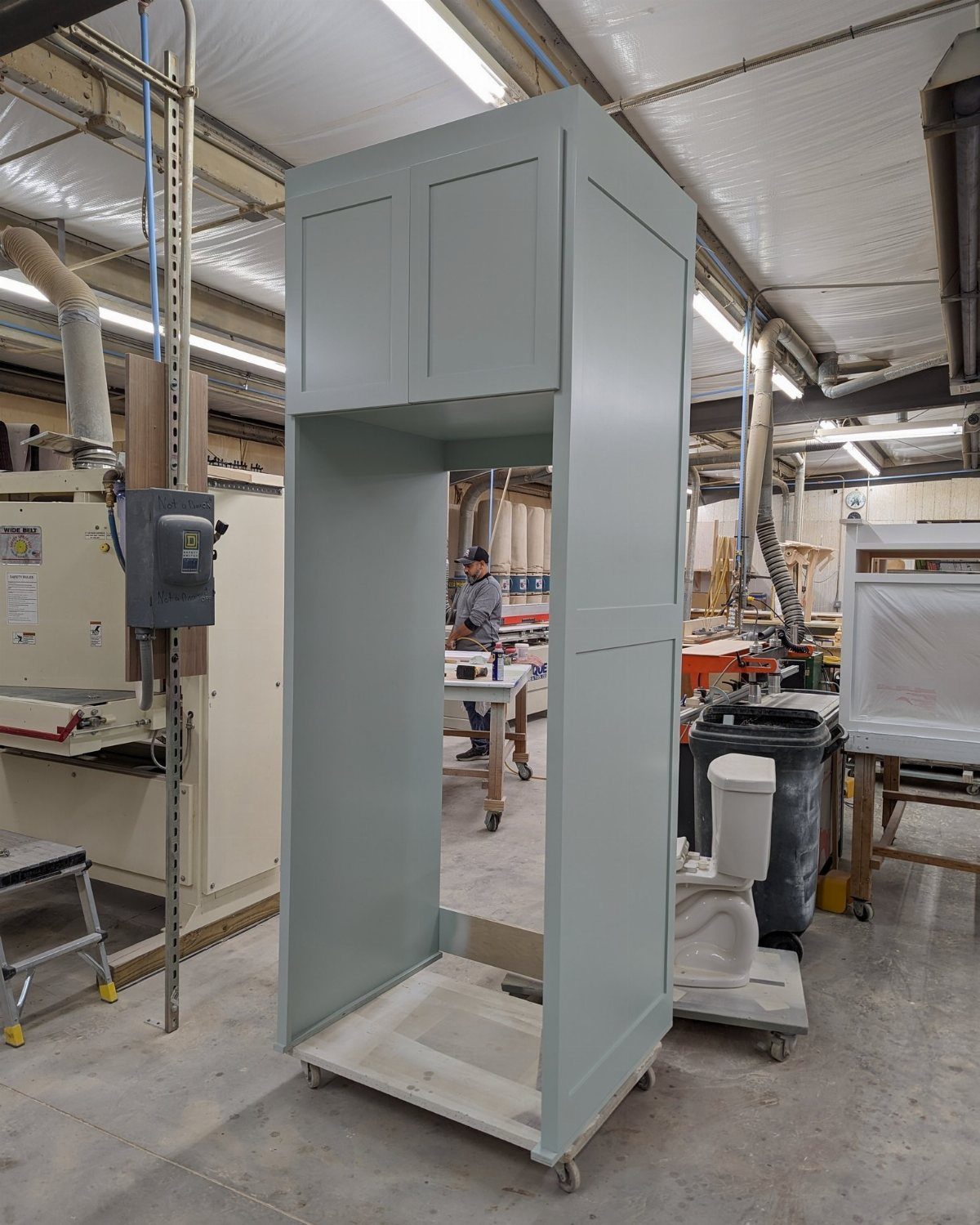 A light blue custom cabinet unit with a large opening designed for a refrigerator.