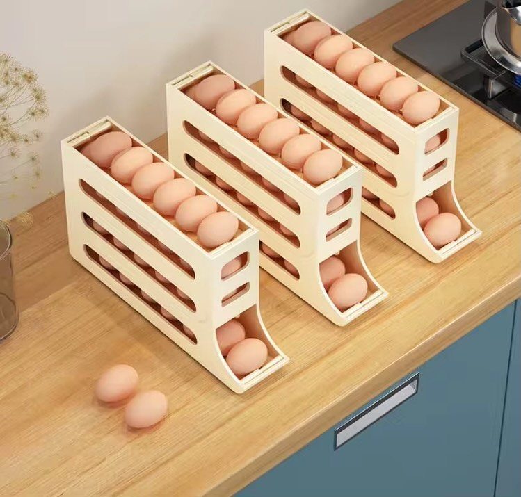 Three cream-colored tiered egg organizers filled with brown eggs on a wooden kitchen countertop.