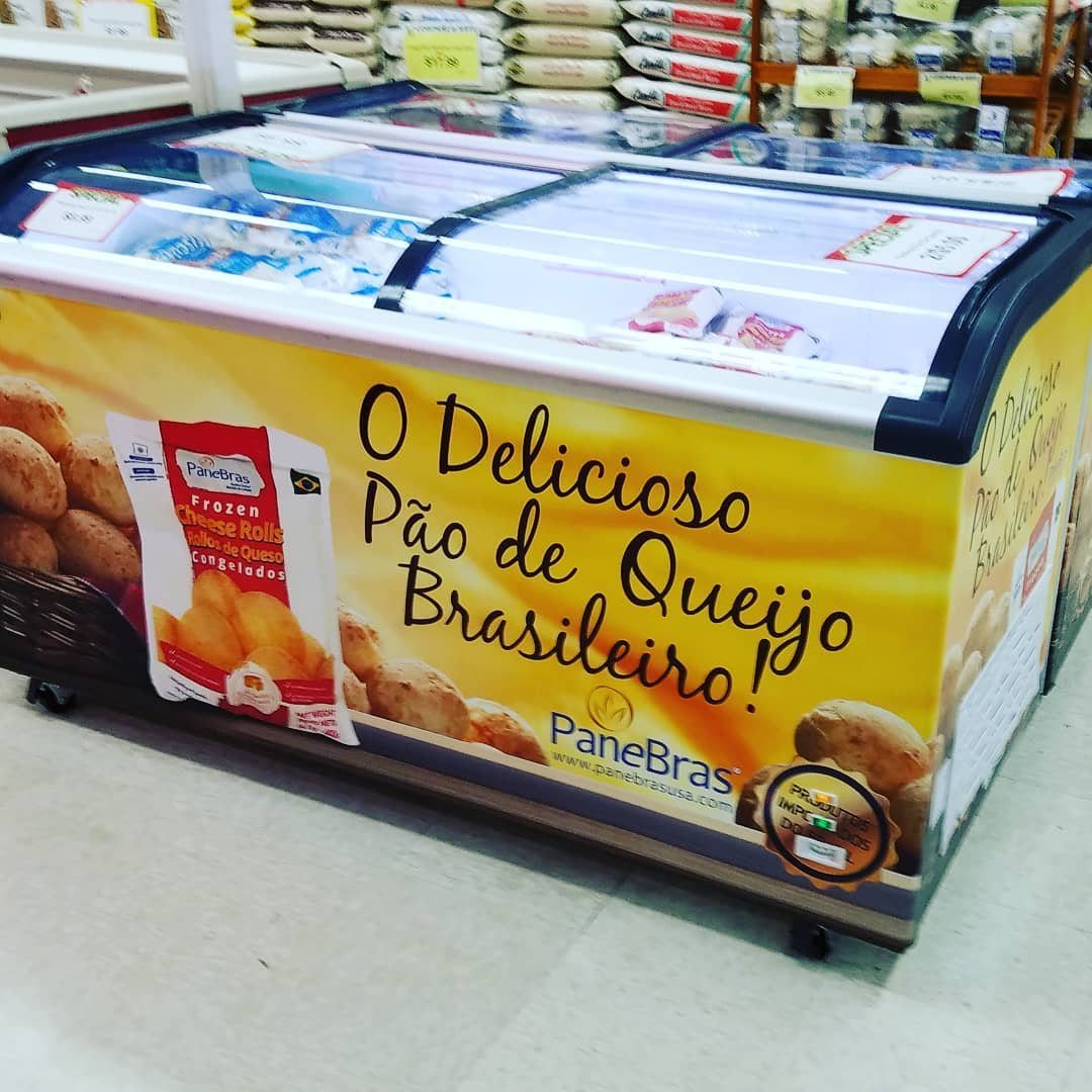 A commercial freezer chest wrapped in a custom yellow design featuring Brazilian cheese rolls.