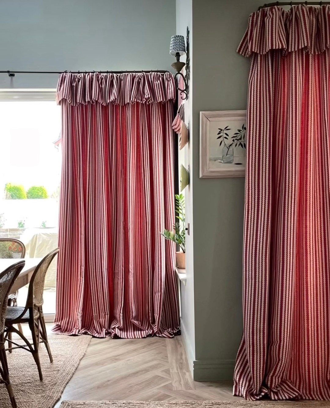 Red and white striped curtains with ruffled tops hanging in a modern living room.