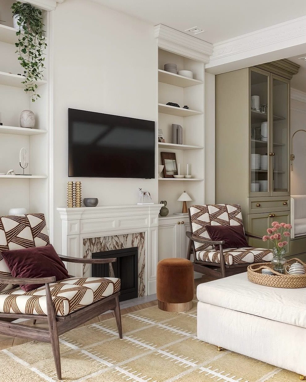 Patterned armchairs with velvet pillows and a velvet ottoman in a bright living room.