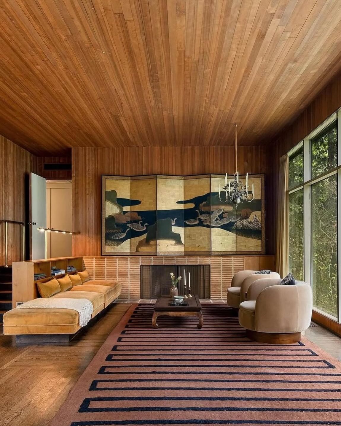 A mid-century living room with extensive wood paneling on the walls and ceiling.