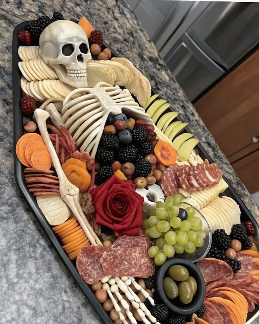 A charcuterie board shaped like a human skeleton using meats, cheeses, and fruits.