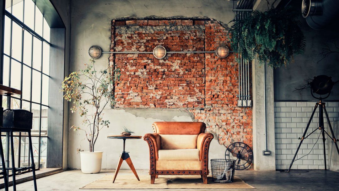 Exposed red brick wall section set within a grey concrete wall in an industrial room.