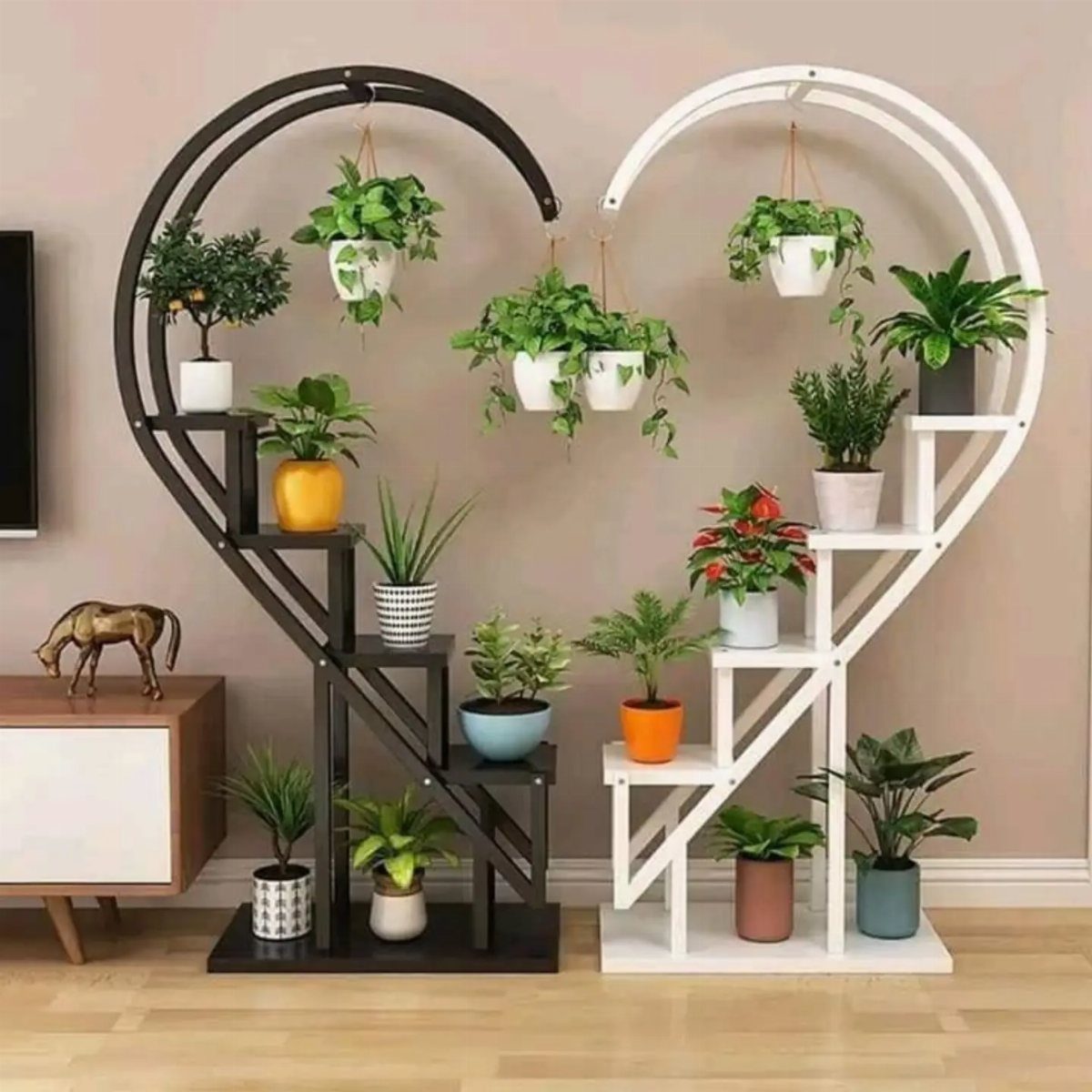 Two heart-shaped tiered plant stands holding various green indoor plants in colorful pots.
