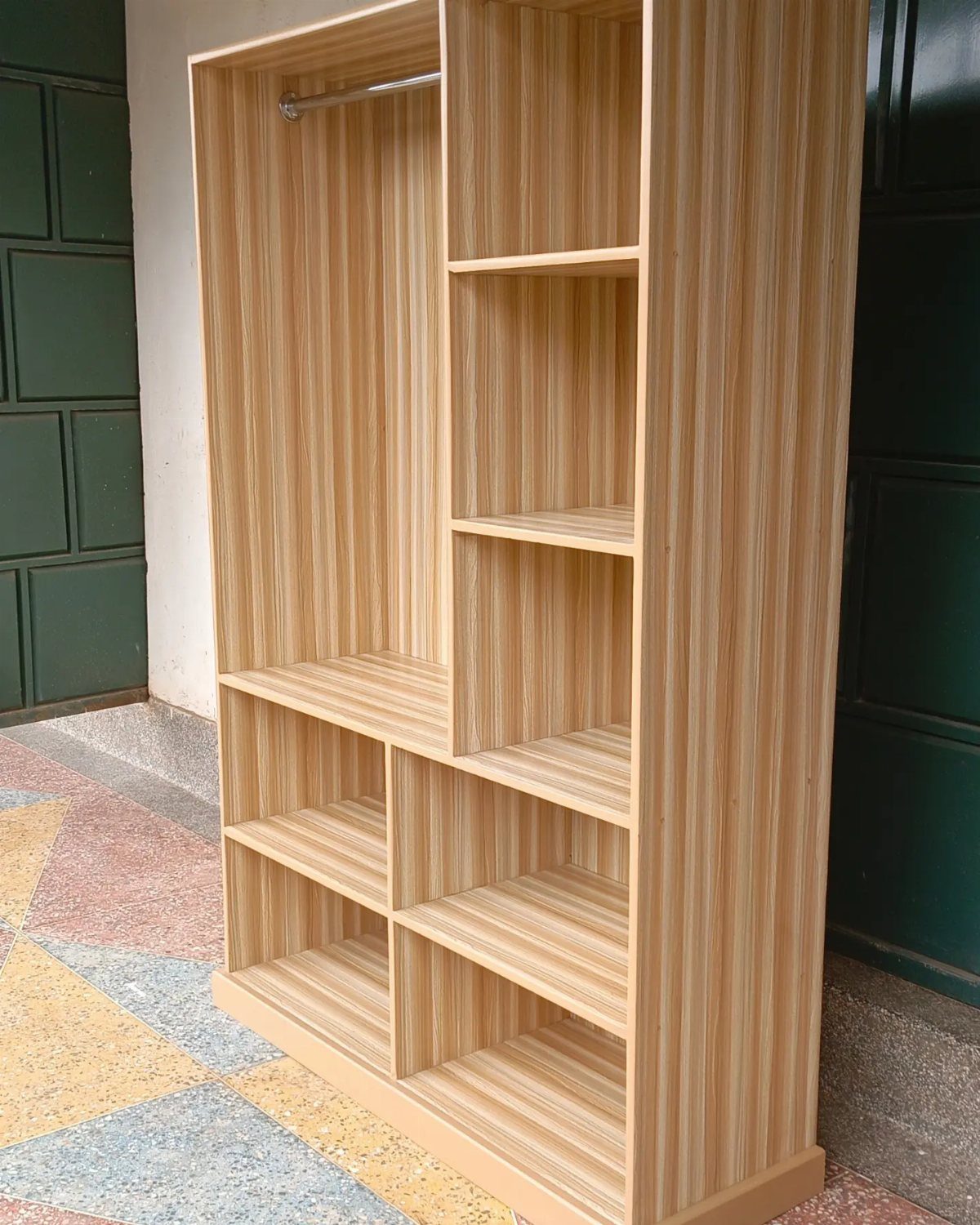 Light wood grain open wardrobe unit with hanging rod and multiple storage shelves.