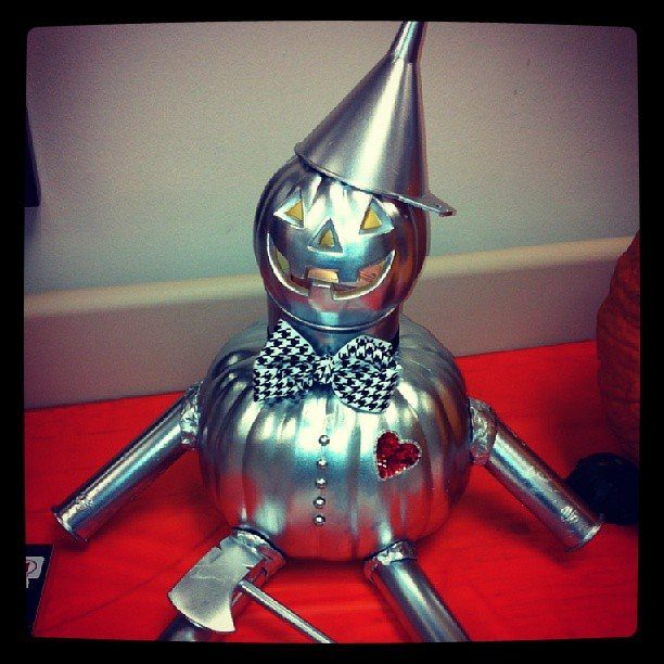 Silver painted pumpkin character styled as the Tin Man with a bow tie and heart.
