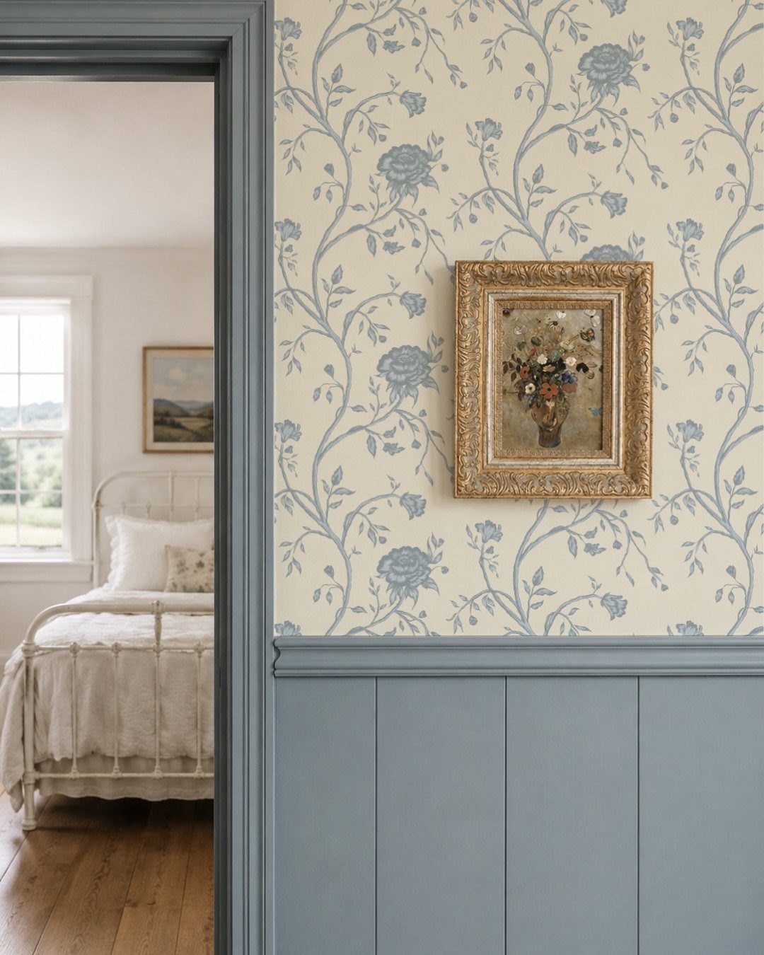 Blue floral pattern wallpaper on a cream background above blue wainscoting in a home interior.