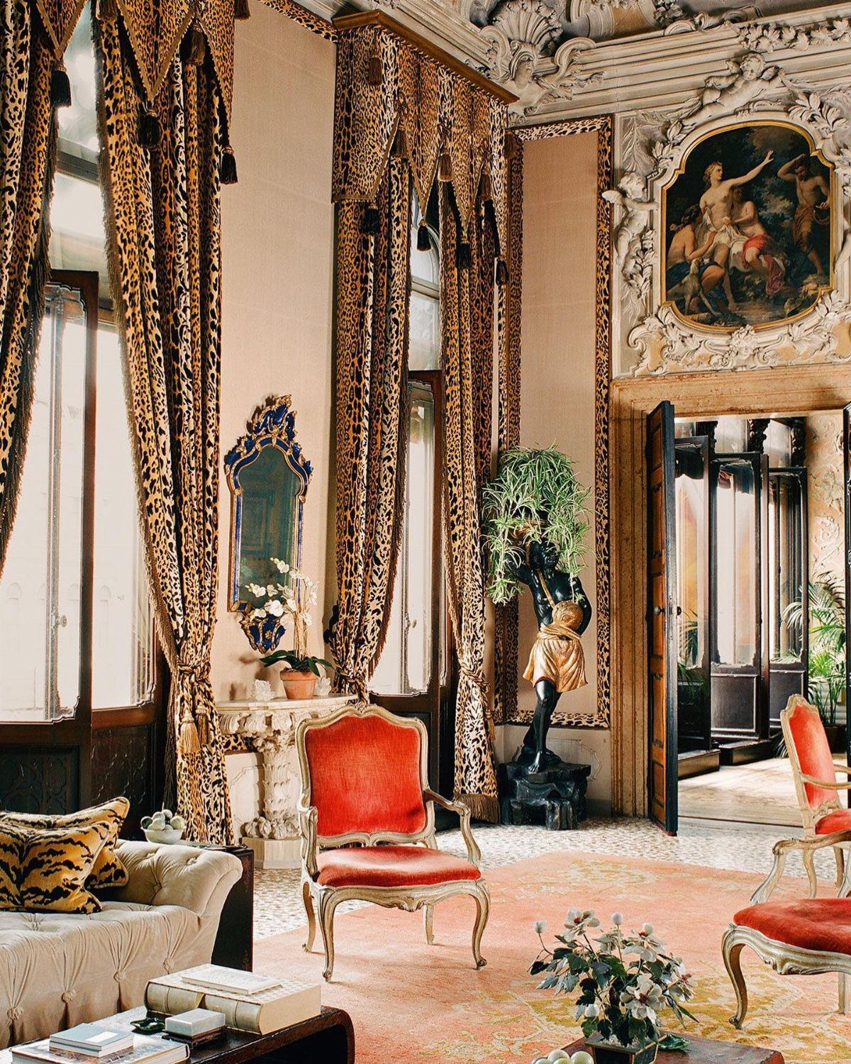 Leopard print curtain panels framing tall windows in an ornate, classical room.