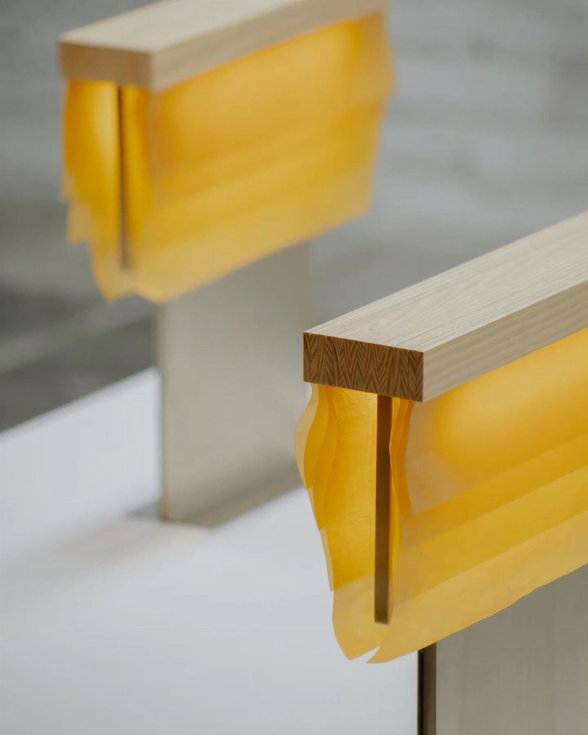 Two modern table lamps with light wood bases and amber wavy glass shades.
