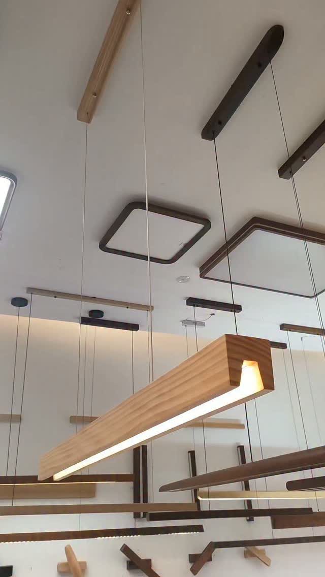Linear wooden pendant lights hanging from a white ceiling with warm integrated LED illumination.