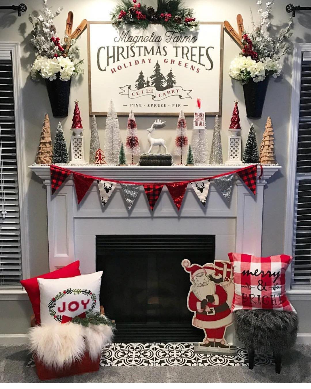 Large Magnolia Farms Christmas Trees sign hanging above a decorated white fireplace mantel.