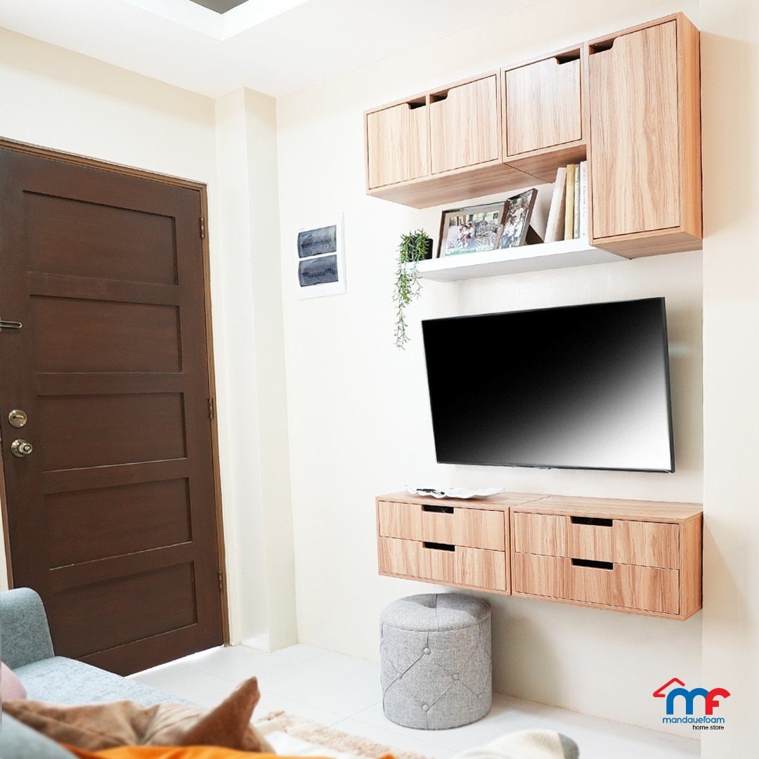 Wooden wall-mounted cabinets and drawers arranged around a television on a white wall.