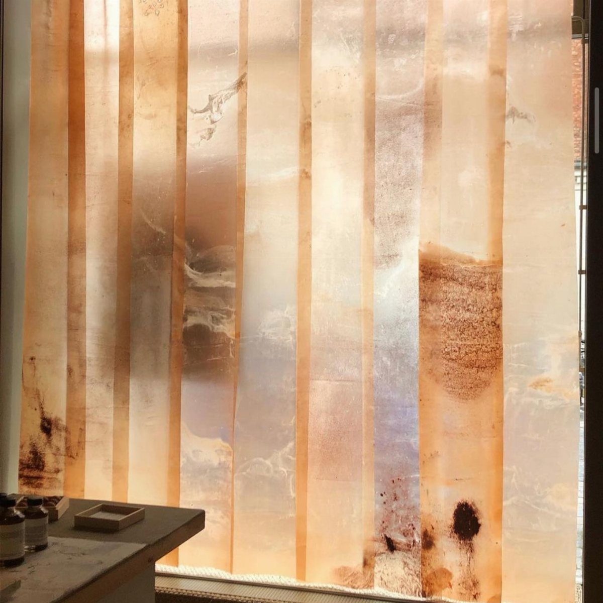 Translucent organic textured panels in amber and cream tones hanging vertically.