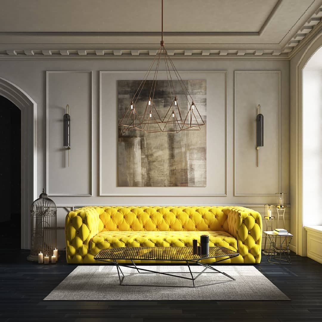 A vibrant yellow tufted velvet sofa positioned in a sophisticated neutral-toned luxury living room.